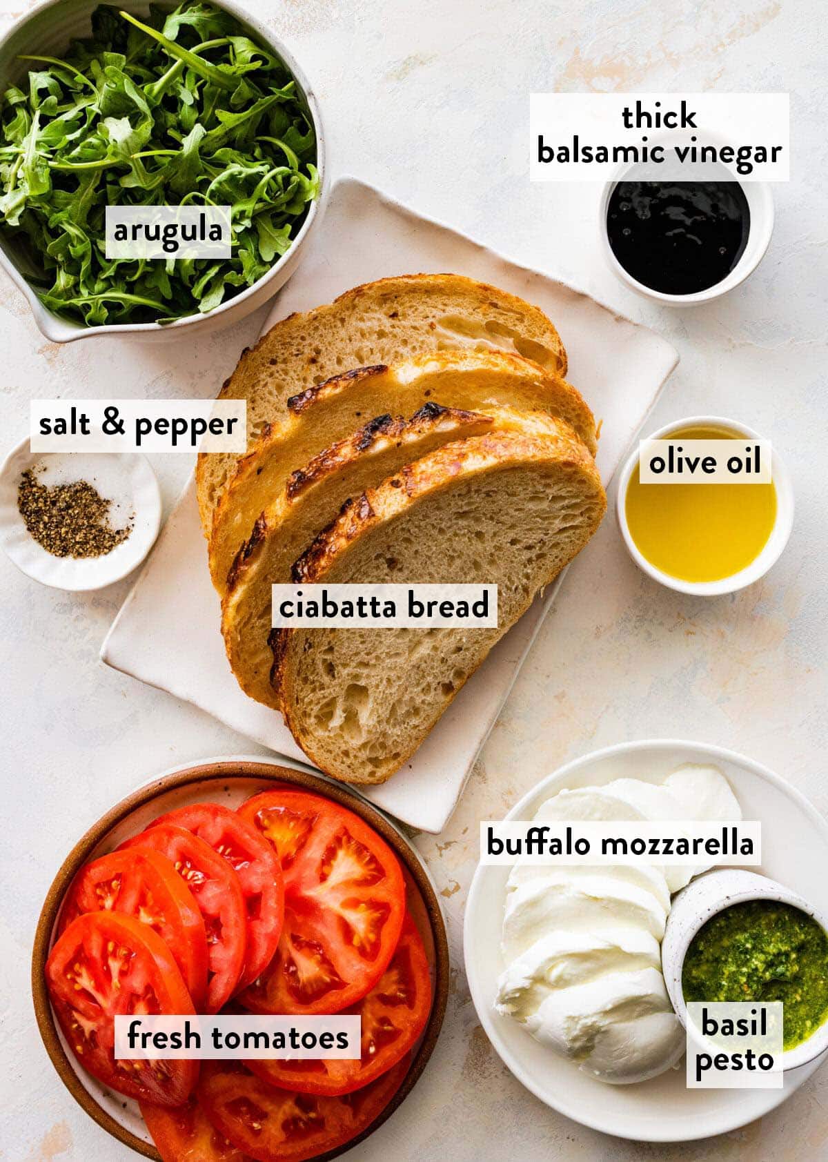 bowls of ingredients for caprese panini on a marble counter.