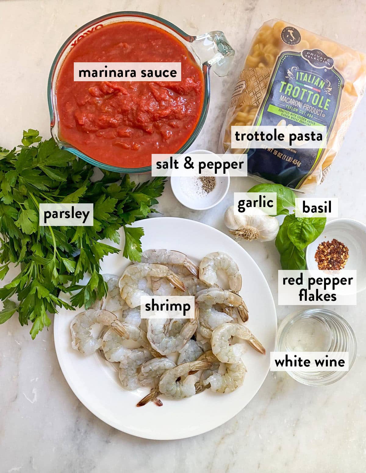 bowls of ingredients for shrimp fra diavolo on a marble surface.