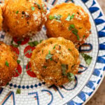 A plate of fried ravioli with garnish.