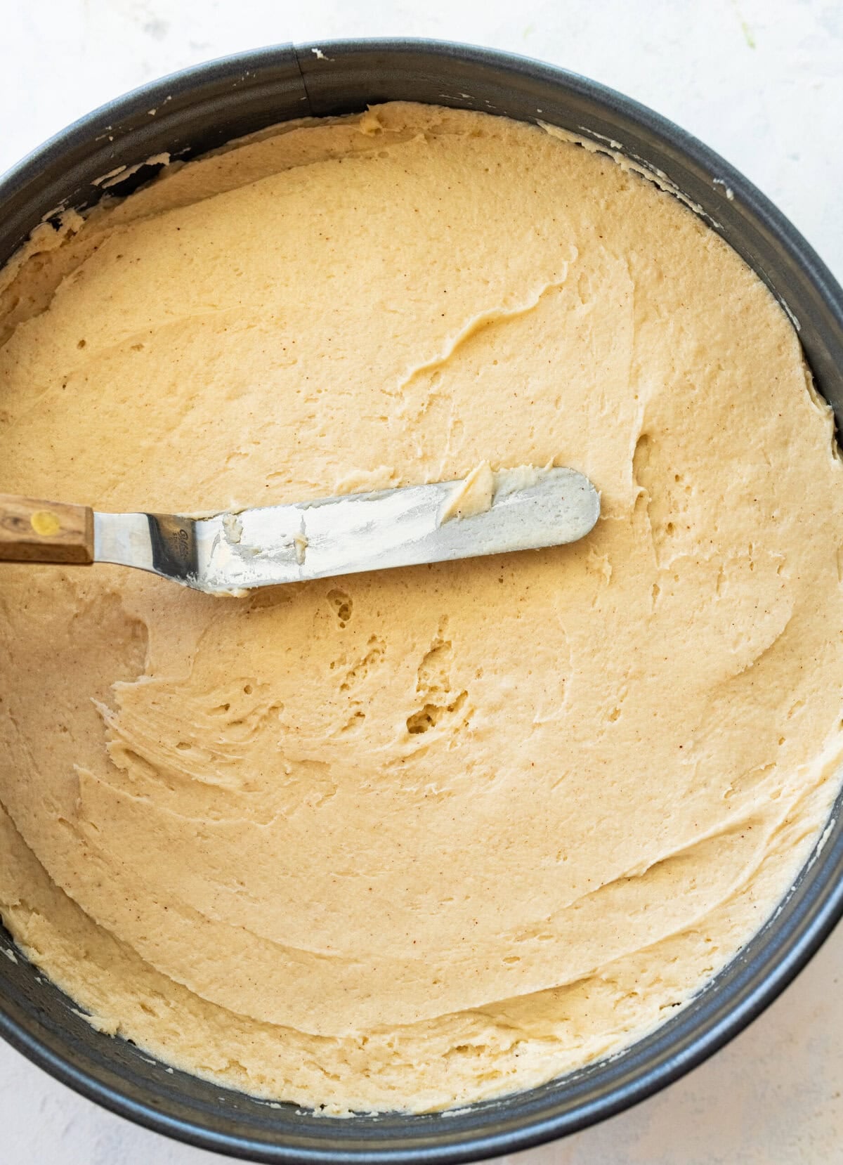 Smoothing the batter over the caramel layer.