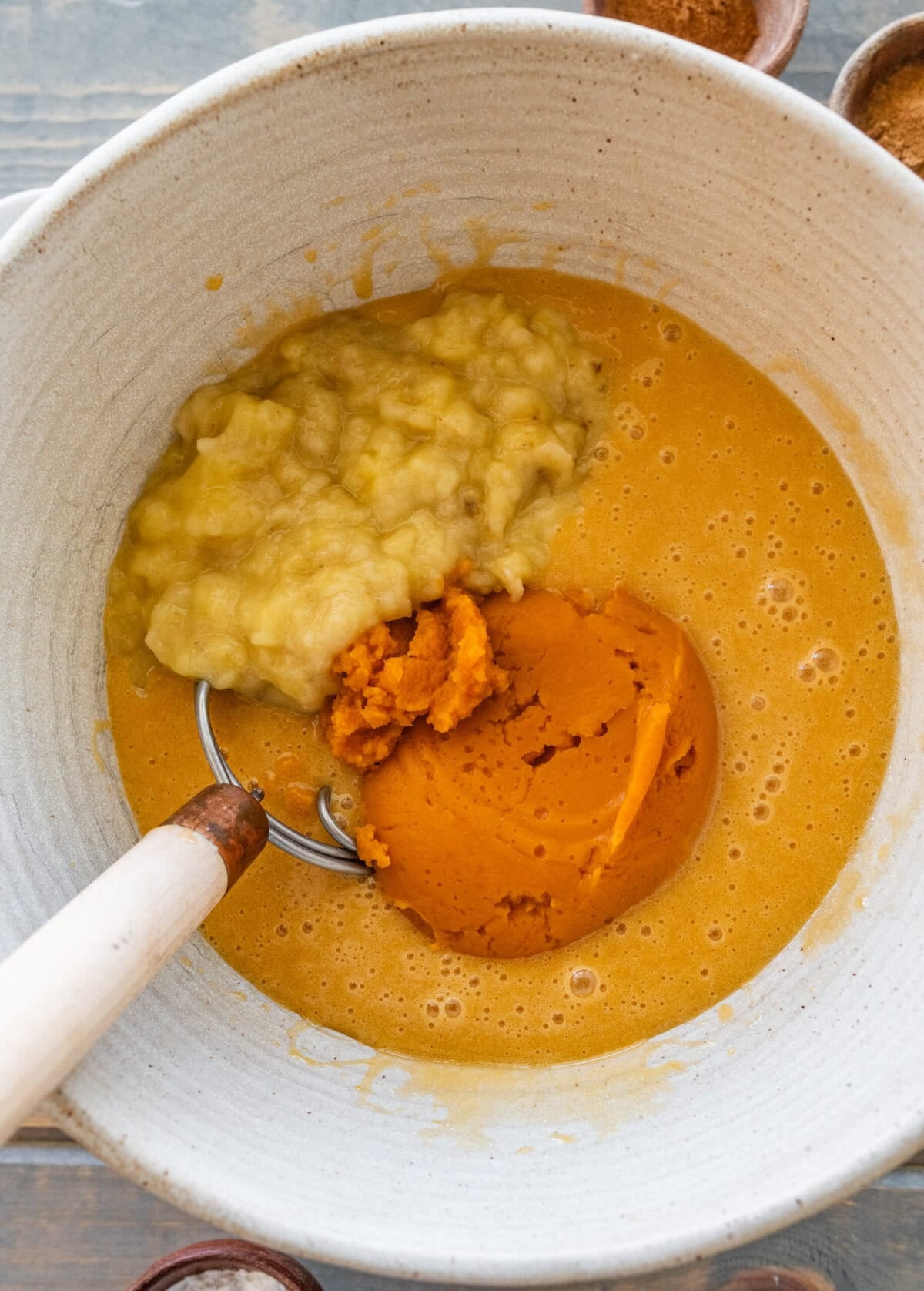 A bowl of muffin batter with mashed bananas and pumpkin added.