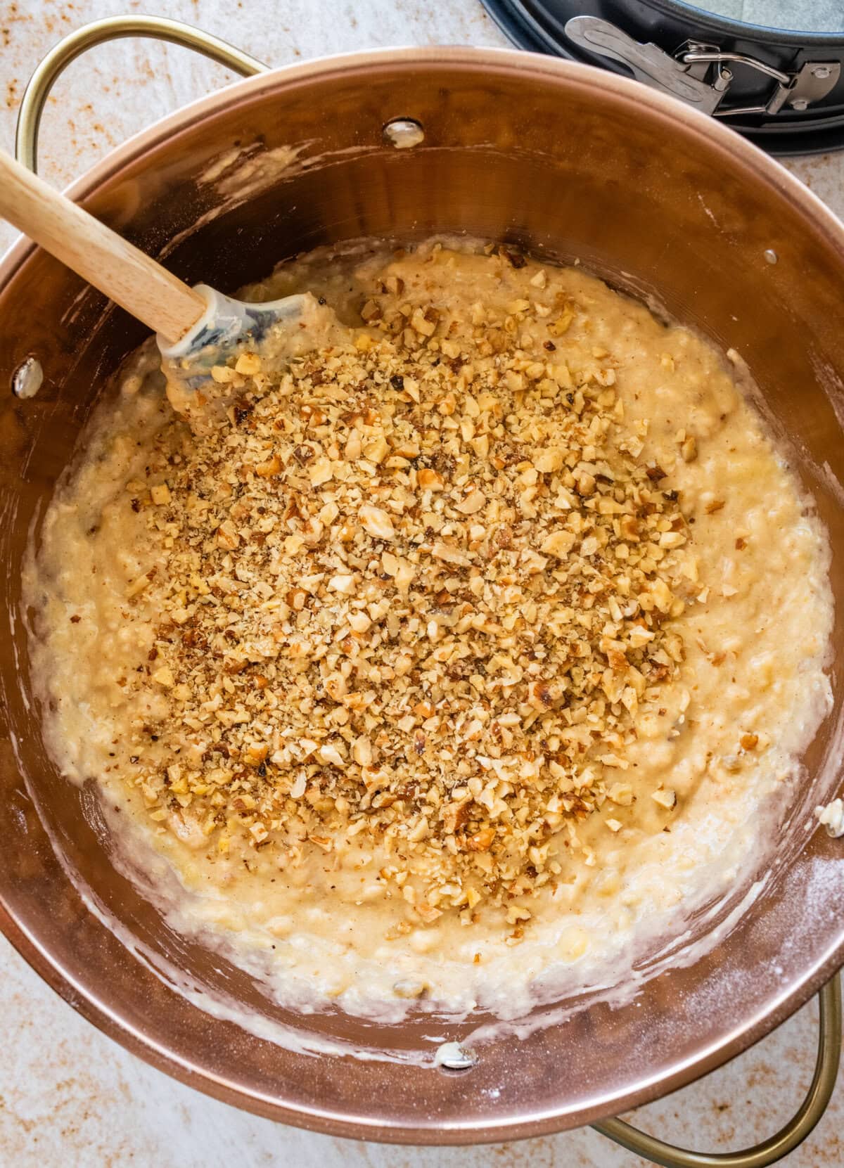 The walnuts added to the bowl of batter.