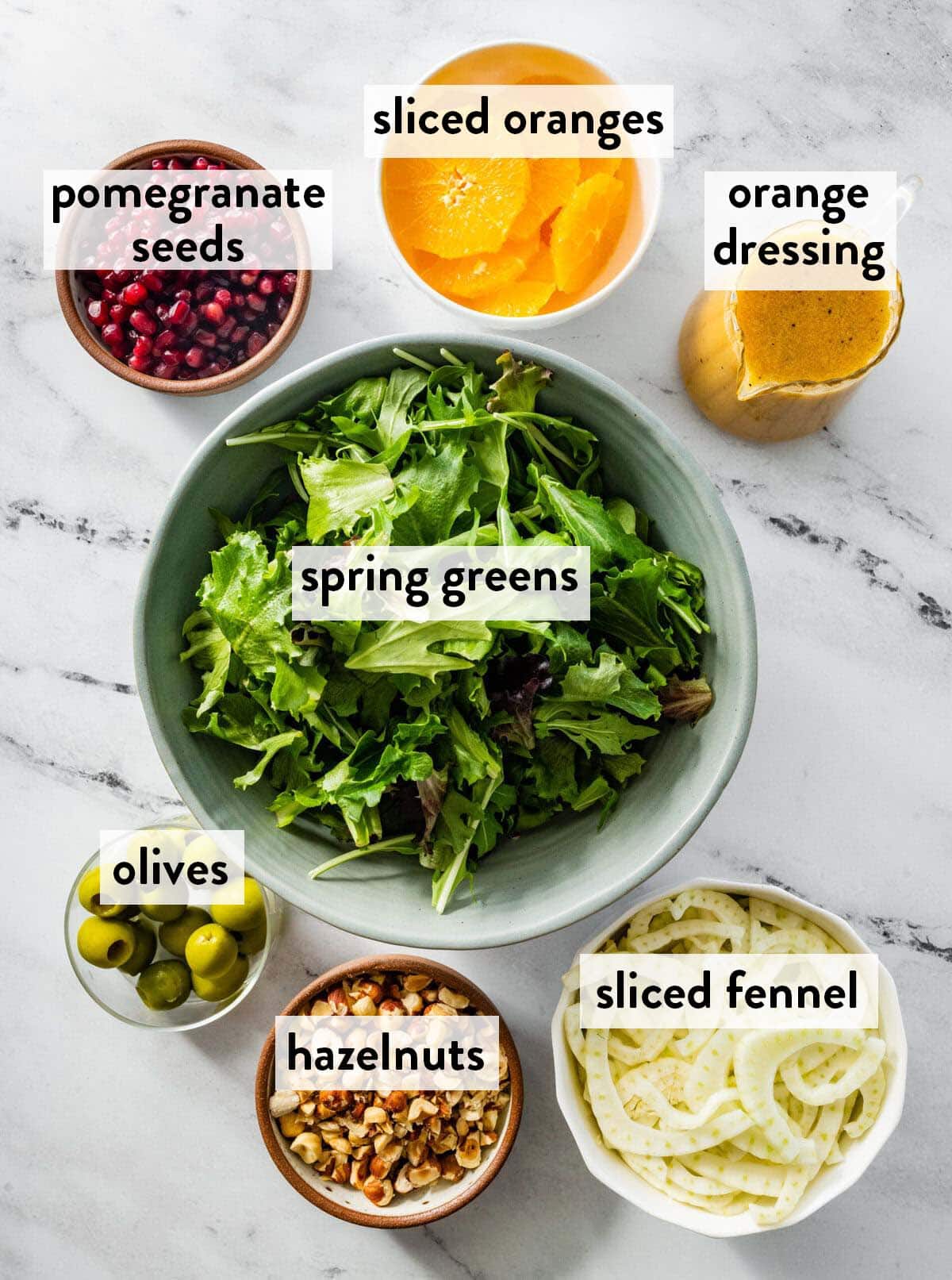 bowls of ingredients for Italian orange fennel salad on a marble surface.