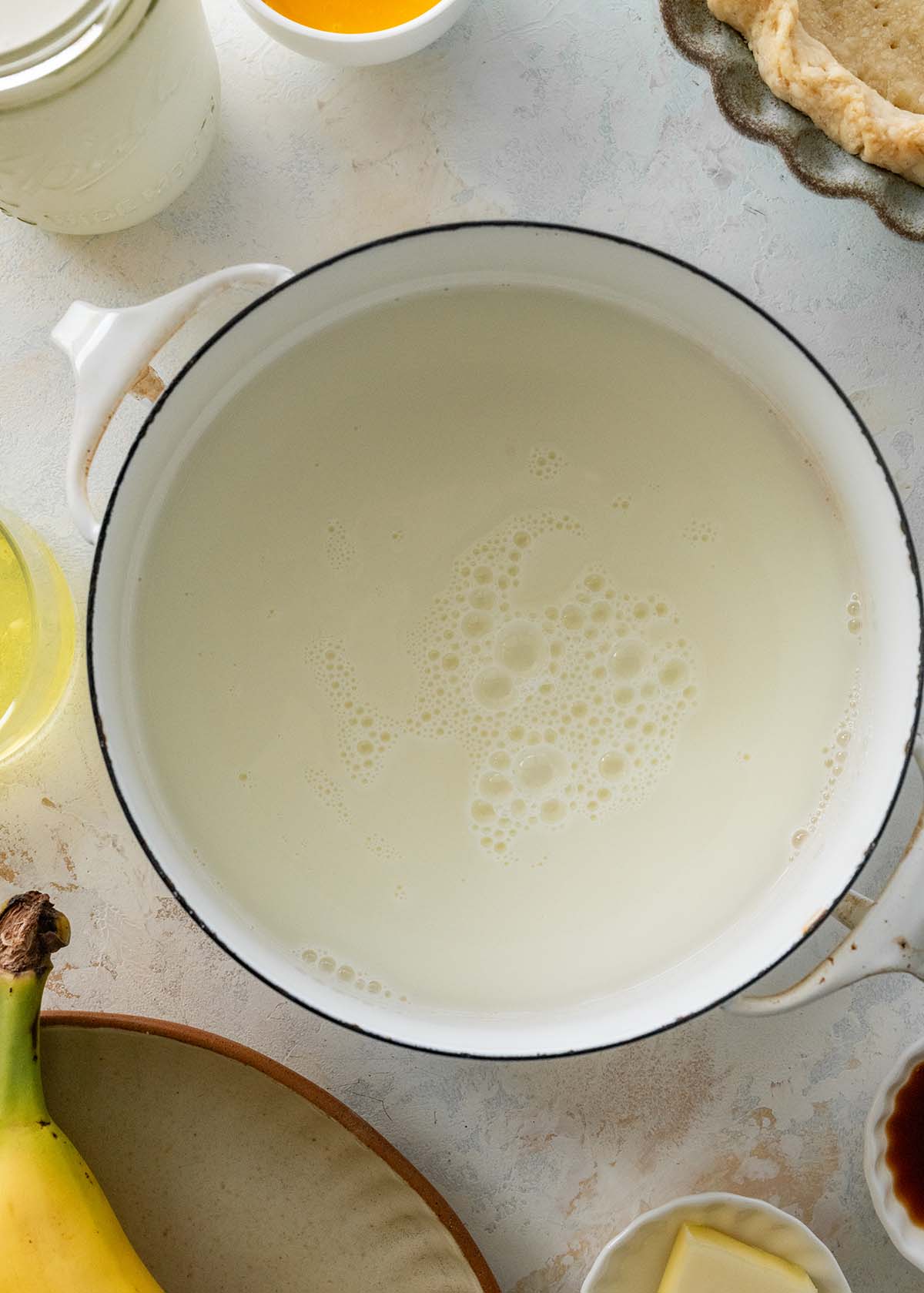 saucepan of hot milk on a marble countertop.
