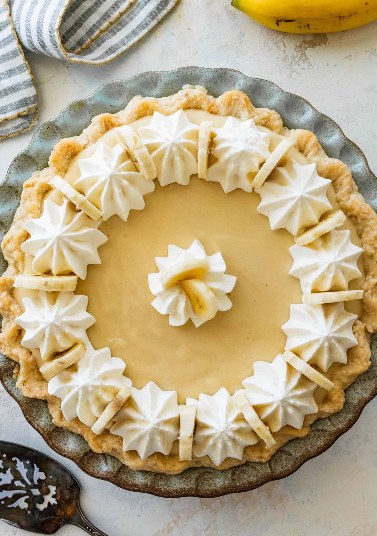 banana cream pie decorated with sliced bananas and whipped cream.