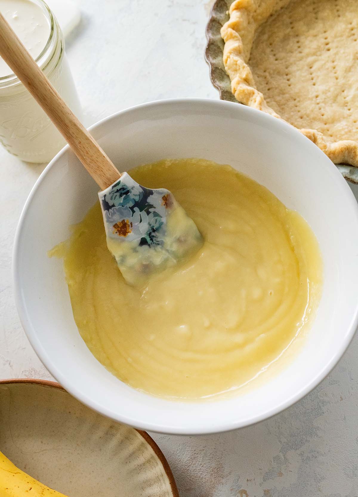 vanilla cream filling in a white bowl with a spatula.