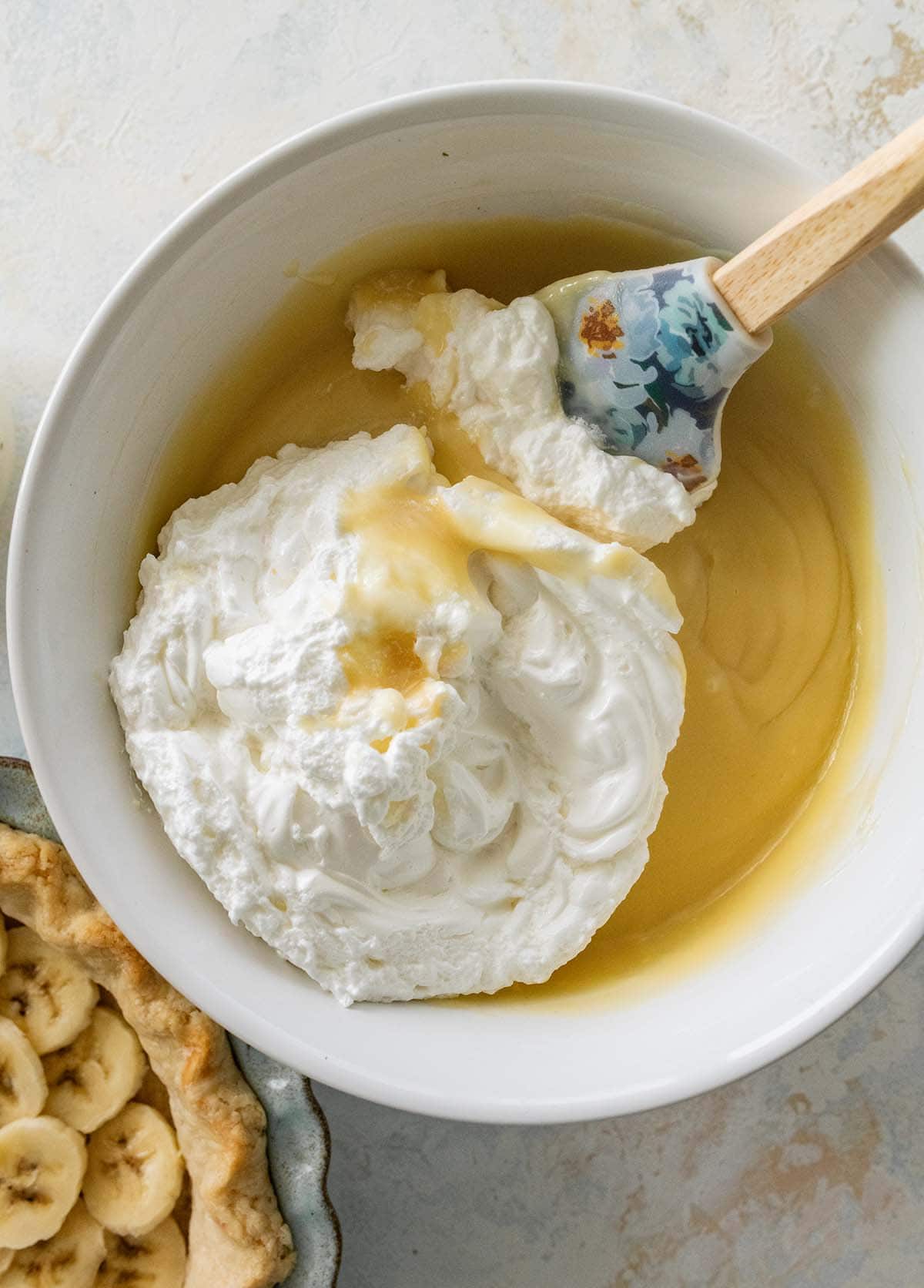 folding the whipped egg whites into the vanilla filling.