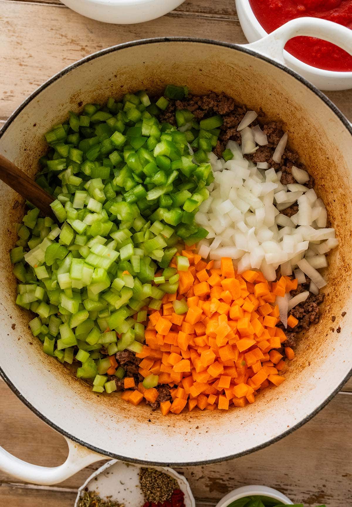 adding sofritto to the browned ground beef in a Dutch oven.